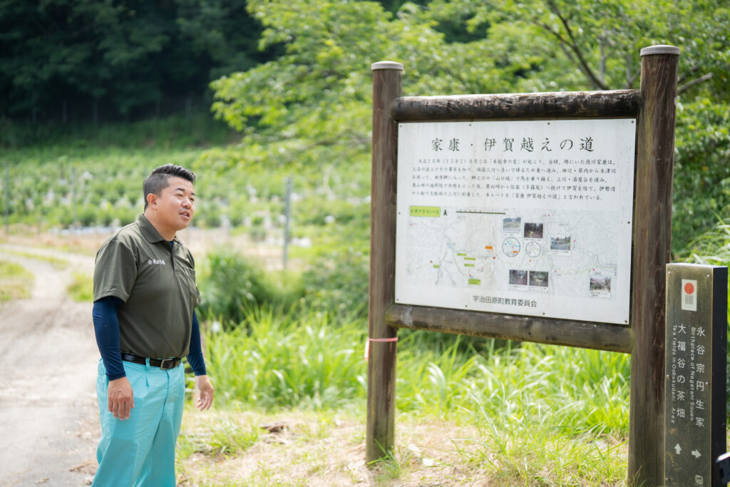 「家康・伊賀越えの道」の看板の前で語る浅田さん