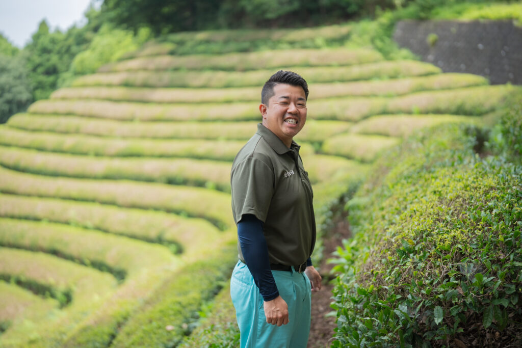 茶畑で笑顔を見せる浅田さん